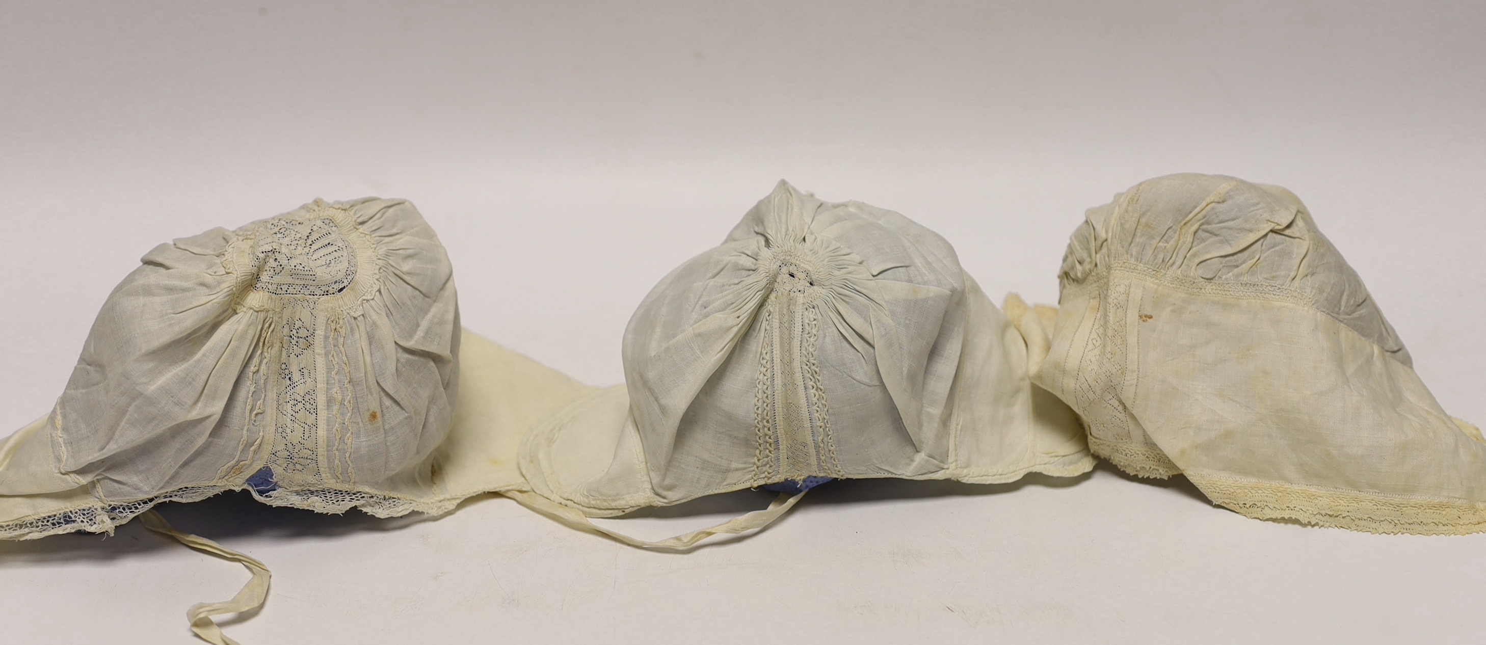 An early 18th century Hollie point insertion baby’s linen vest, three baby bonnets with Hollie point insertions and an early 18th century pair of Flemish bobbin lace lappets, a partly finished needlepoint length of lace,